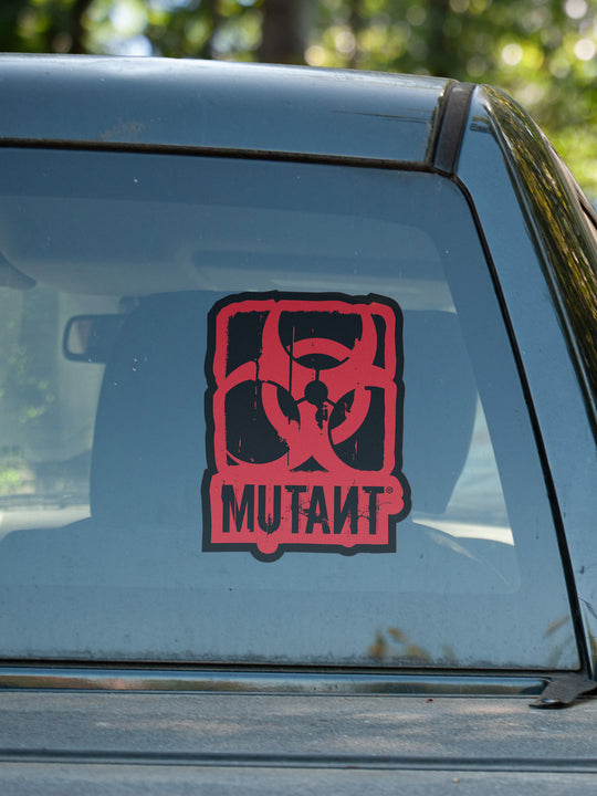 A photo showing the Rugged Truck Window Decal, which features the MUTANT logo in red on a shaped black background, applied to the rear glass of a truck.